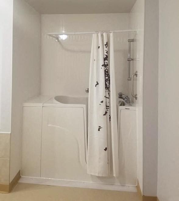 A white bathroom with a shower curtain and a white sink.